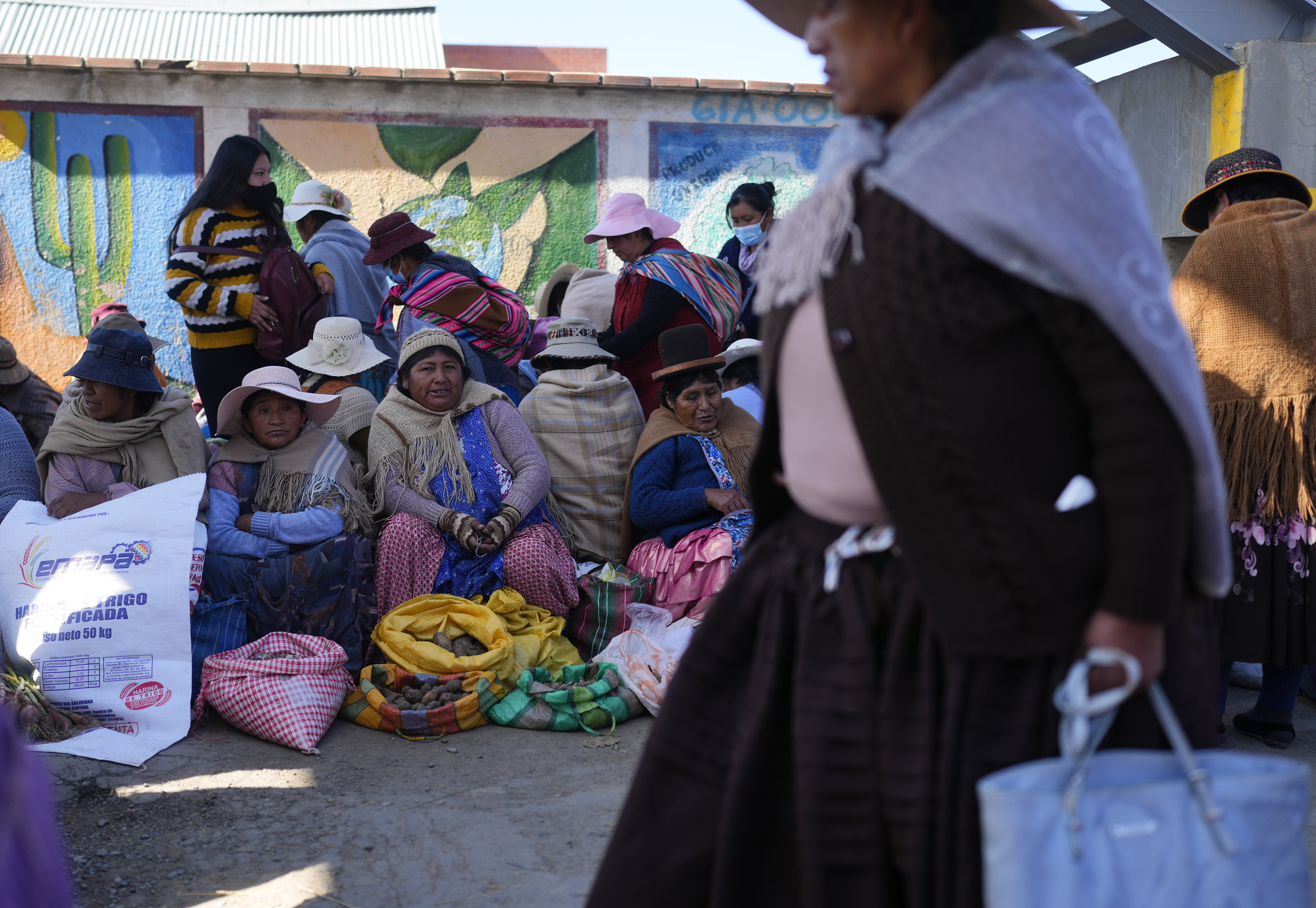 Vendedoras de papas esperan compradores en un mercado callejero en El Alto, Bolivia, el martes 11 de abril de 2023. (AP Foto/Juan Karita)