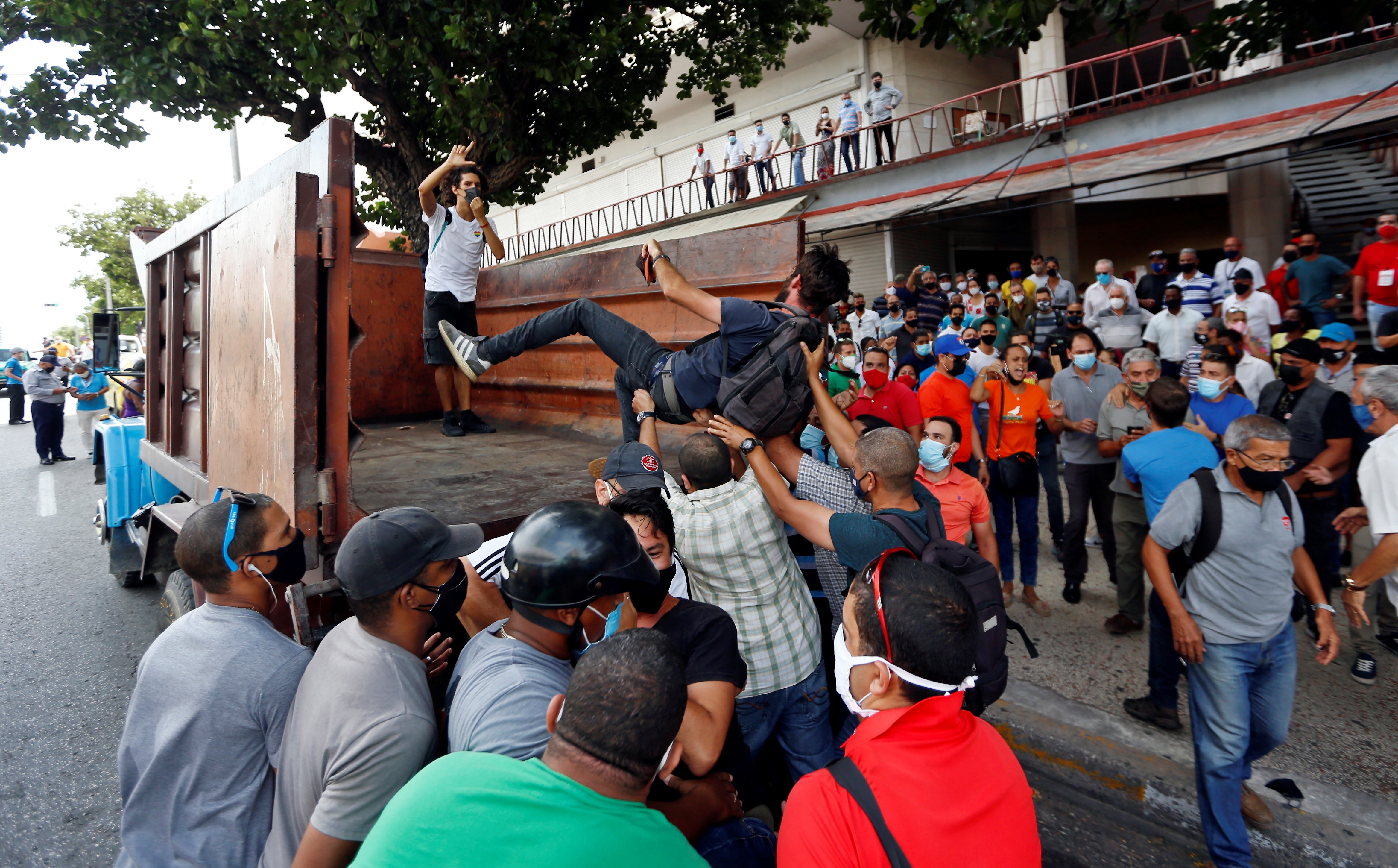 Manifestantes frente al Instituto de Radio y Televisión (ICRT) mientras son subidos en un camión en una calle en La Habana (EFE/Ernesto Mastrascusa/Archivo) 