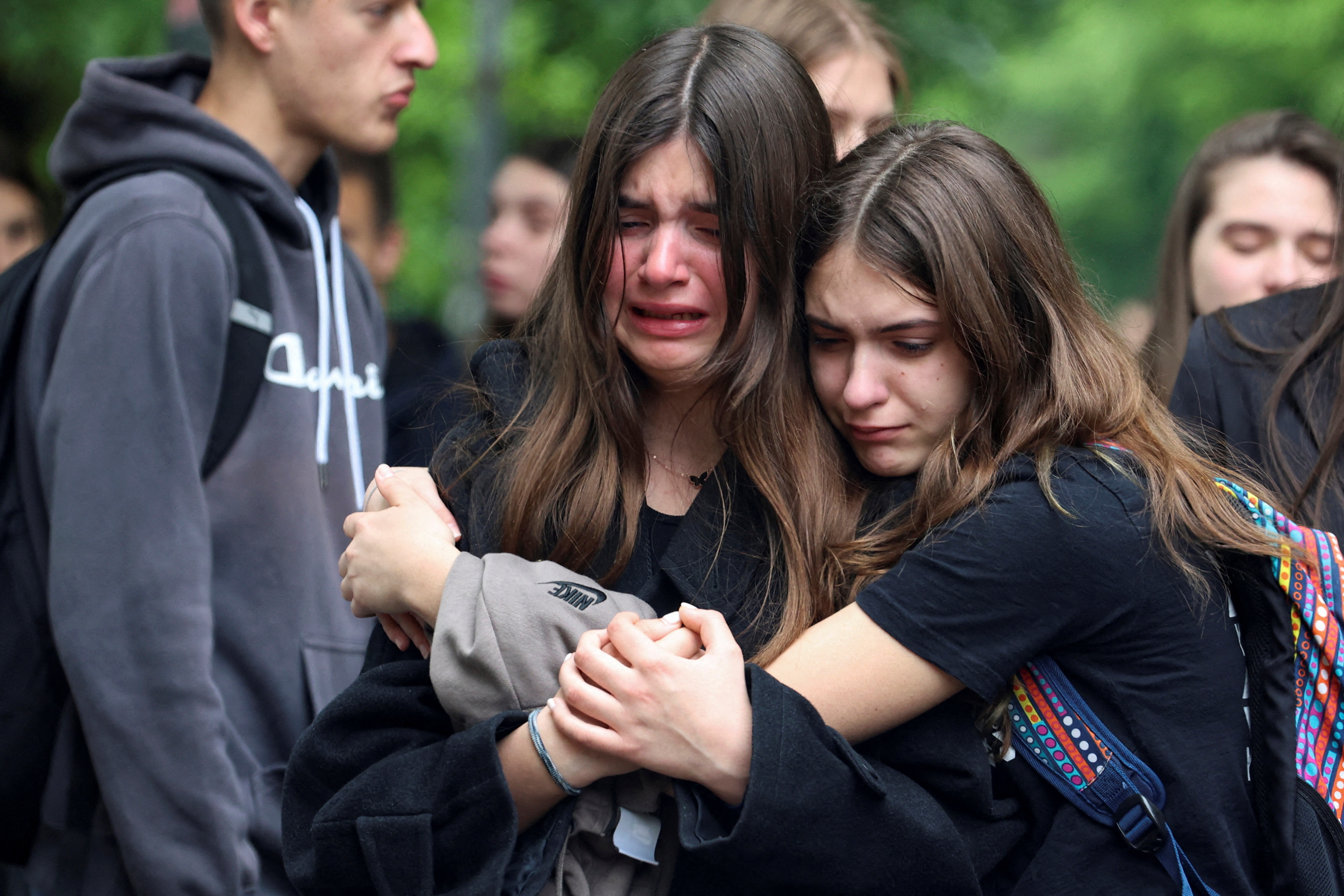 Dos jóvenes lloran durante la conmemoración por las víctimas del tiroteo en una escuela de Belgrado, el 4 de mayo de 2023. (REUTERS/Zorana Jevtic)